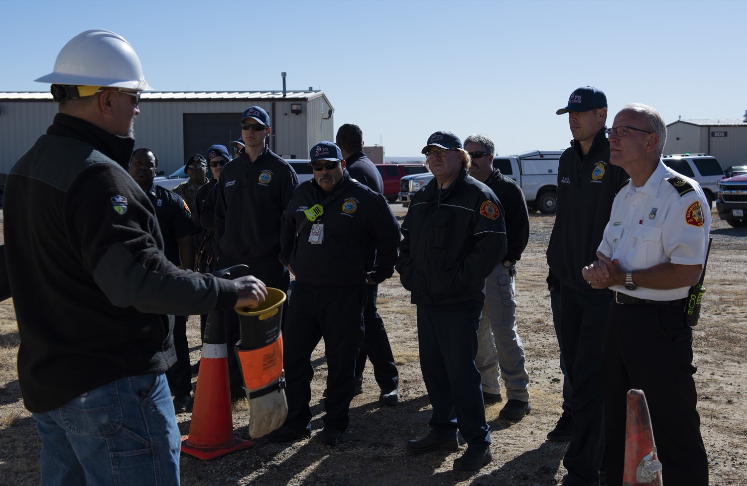 A safety briefing with crews in hard hats